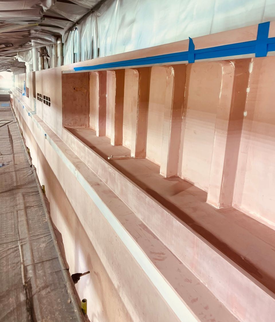 Full fairing stage of a 76m superyacht repaint in a covered paint shed in Singapore